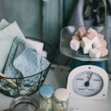 Mic producător care livrează borcane cu produse de casă într-o băcănie cu rafturi din lemn